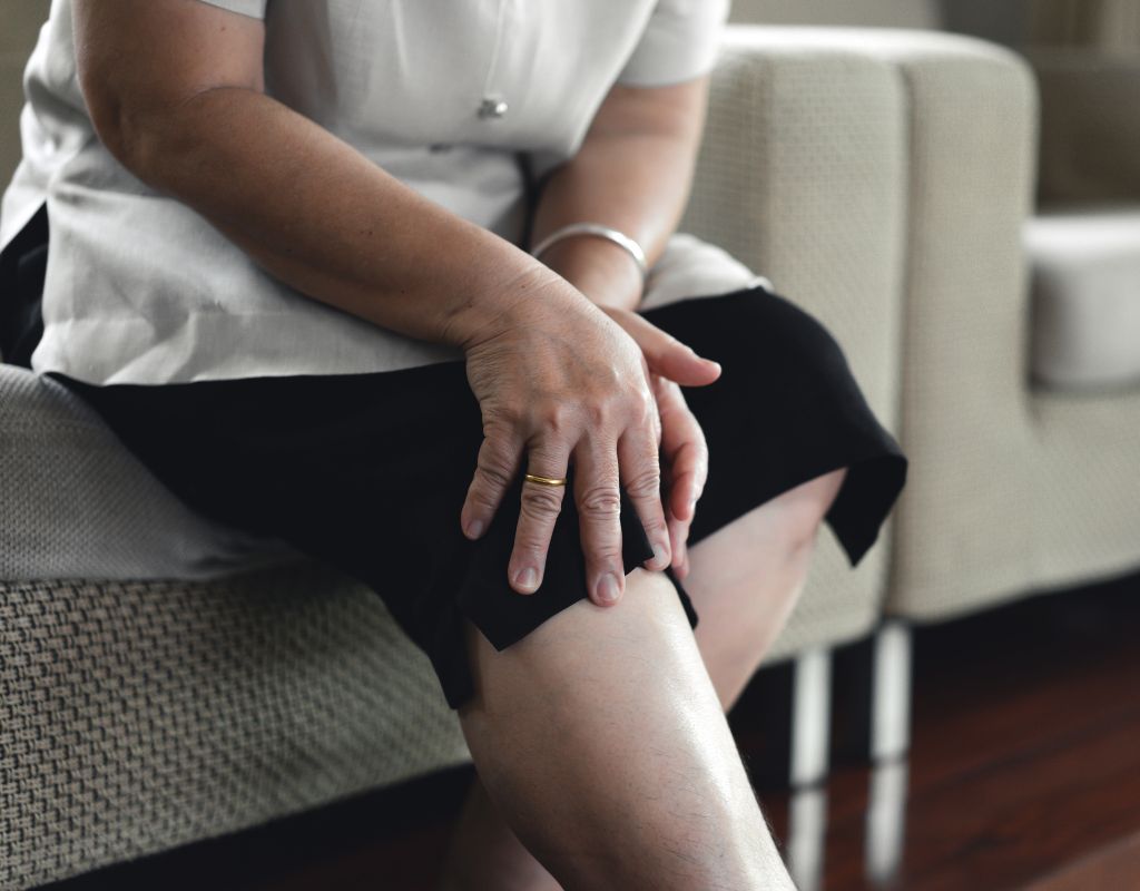 mujer con problemas de artroosis se toca la rodilla